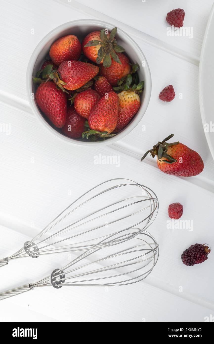 piatto con fragole, frutta rossa come ingredienti per la cucina e arnese in studio, carta da parati Foto Stock