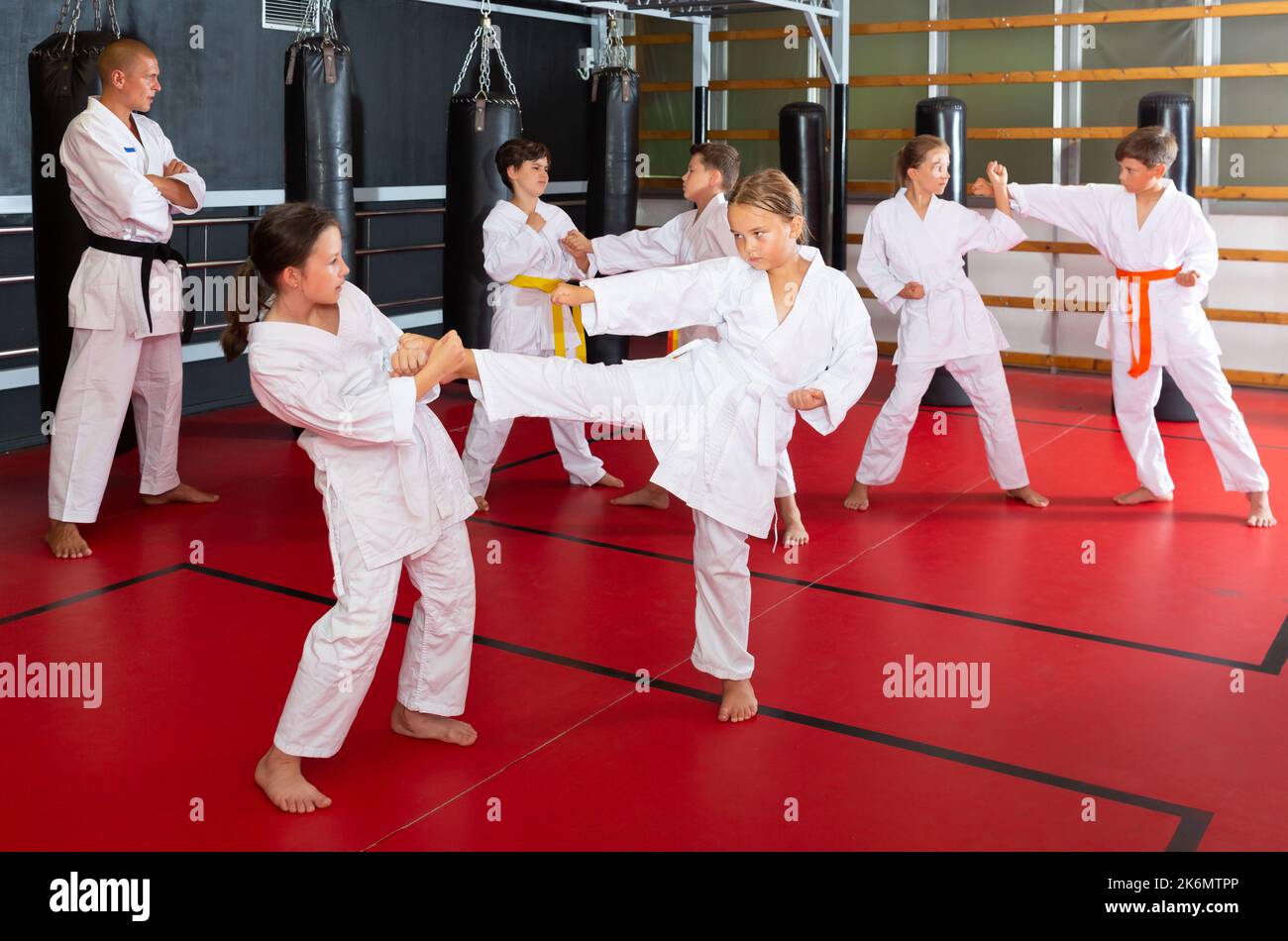 Ragazzi che lavorano in coppia, padroneggiare i calci in classe karate Foto Stock