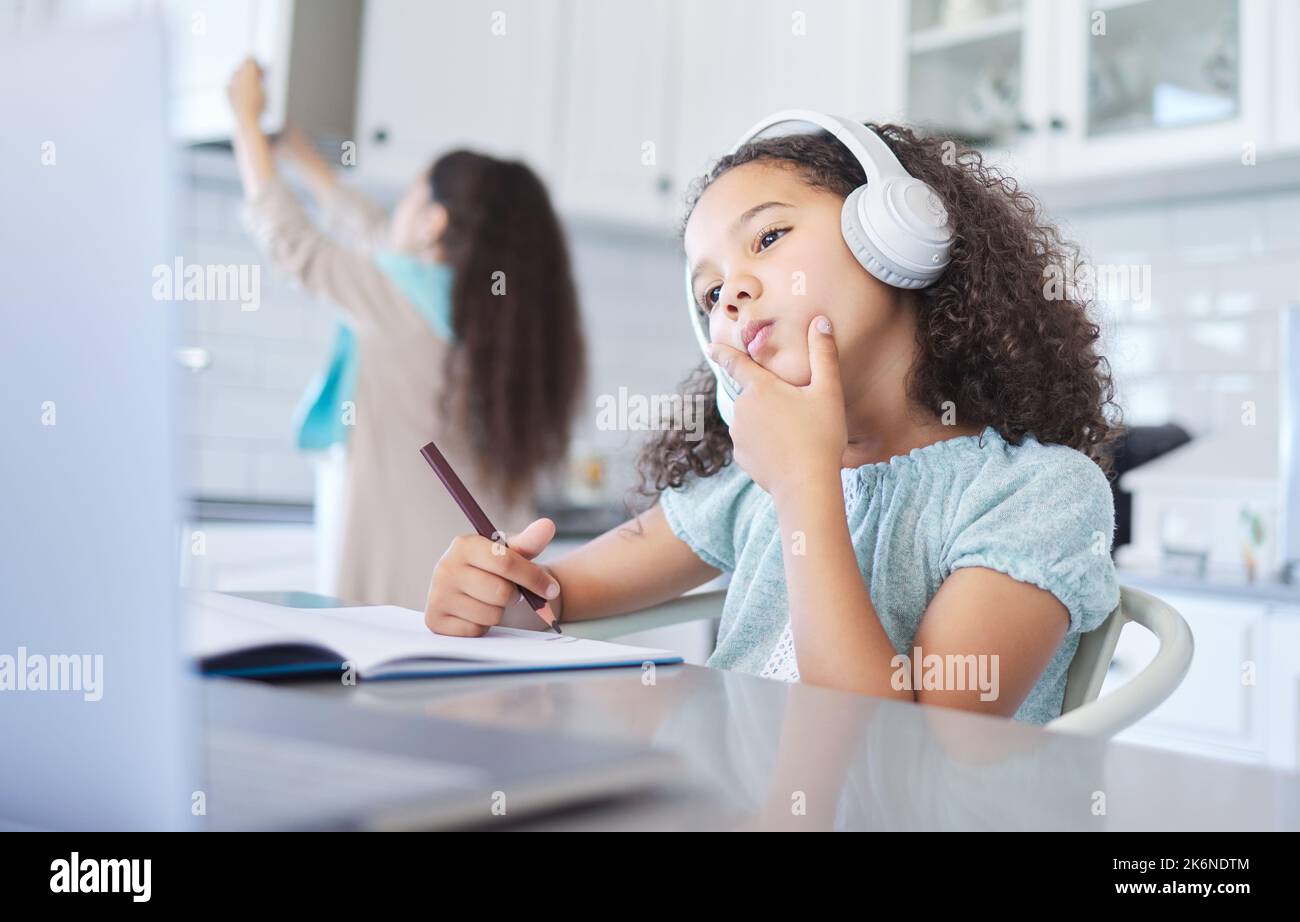 Parla liberamente, potresti cambiare il mondo. una bambina che guarda pensierosa bene facendo il suo lavoro al tavolo da cucina. Foto Stock