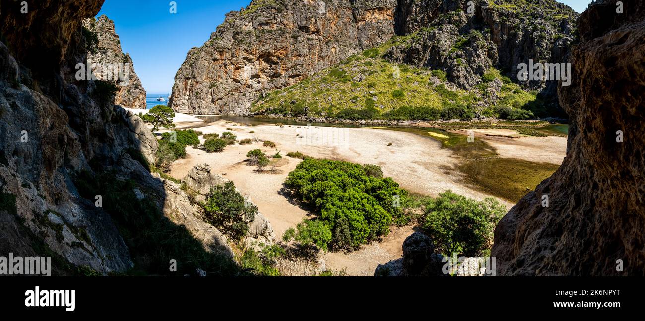 Ampia vista panoramica da una grotta alla spiaggia di ciottoli Cala de SA Calobra in estate nel canyon più profondo di Maiorca, nei monti Serra de Tramuntana. Foto Stock