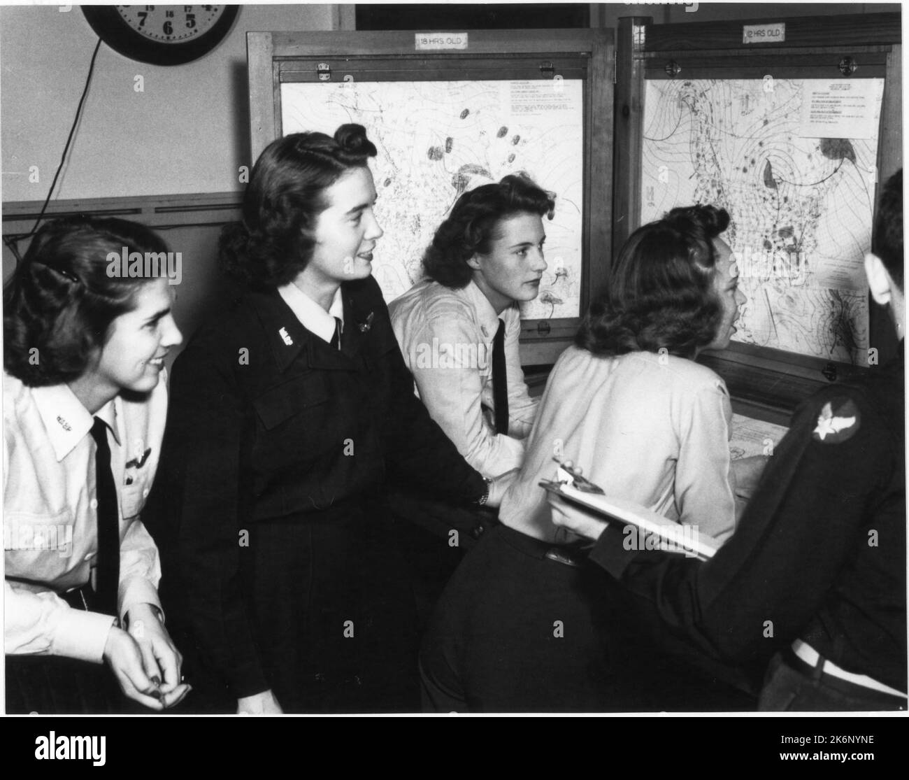 Wasps a Frederick AAF, Oklahoma. Wasps a Frederick AAF, Oklahoma. "Wasps consultarsi con il Lt. Daniel Banes in merito alle condizioni meteorologiche. Da sinistra a destra: Wasps Upson, Winfield, Conklin, Webster e Lt. Banes. Frederick AAF, Frederick, Oklahoma.". 1940 - 1983. Foto Stock