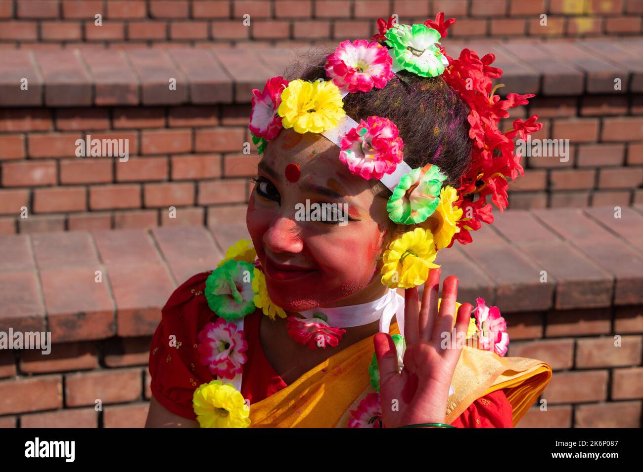 Le donne indossano abiti tradizionali con ornamenti floreali e si esibiscono durante il Festival di Primavera, il primo giorno del mese di Primavera del Bengalese ''Falgun'''. Foto Stock