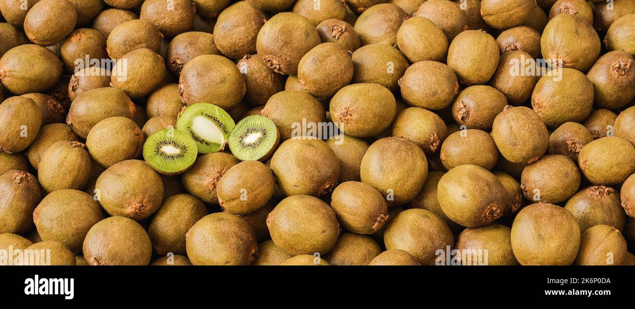 kiwi frutti con kiwi dimezzati in un grande mucchio, immagine del concetto di cibo vegano Foto Stock
