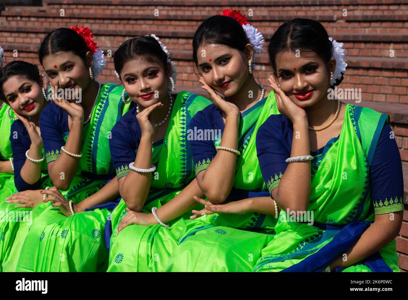 Le donne indossano abiti tradizionali con ornamenti floreali e si esibiscono durante il Festival di Primavera, il primo giorno del mese di Primavera del Bengalese ''Falgun'''. Foto Stock