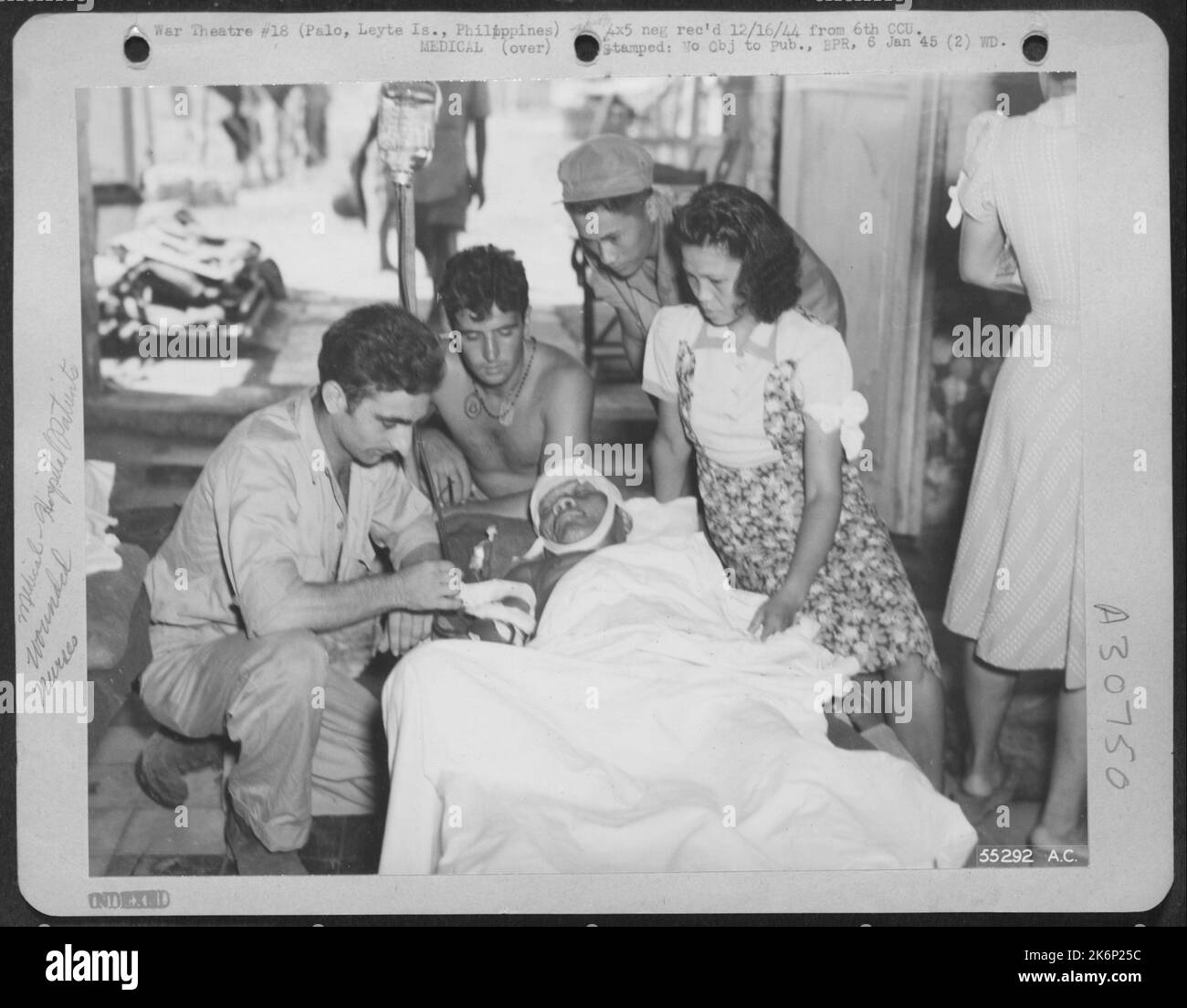 Un difetto di incursioni aeree giapponesi, questo cittadino filippino è stato curato da un medico di un'unità ospedaliera di evacuazione. Giovane assistente donna è una delle infermiere volontarie filippine. Palo, Leyte is., P.I. GRP. Foto Stock
