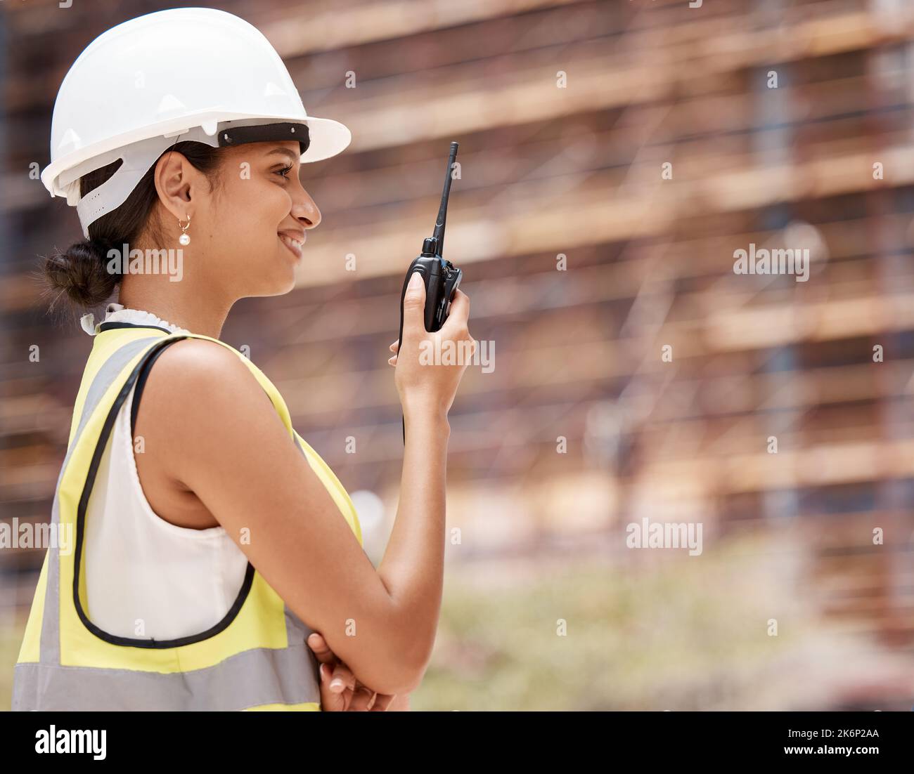 Costruzione, ingegnere e donna con walkie talkie, comunicazione e ispezione. Ingegneria, sviluppo di edifici e lavoratori edili, radio Foto Stock