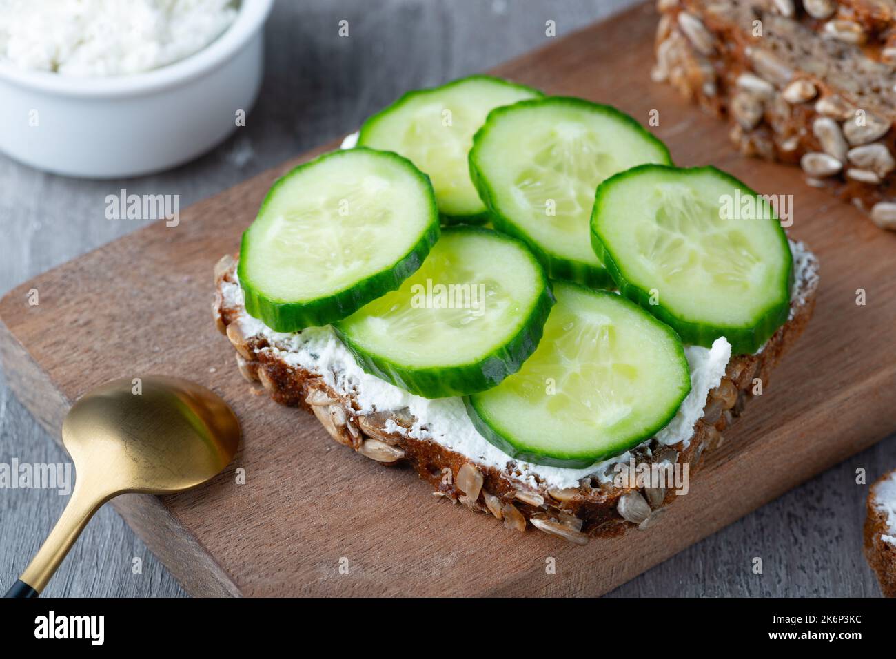 Fette di pane di segale con ricotta e cetrioli Foto Stock