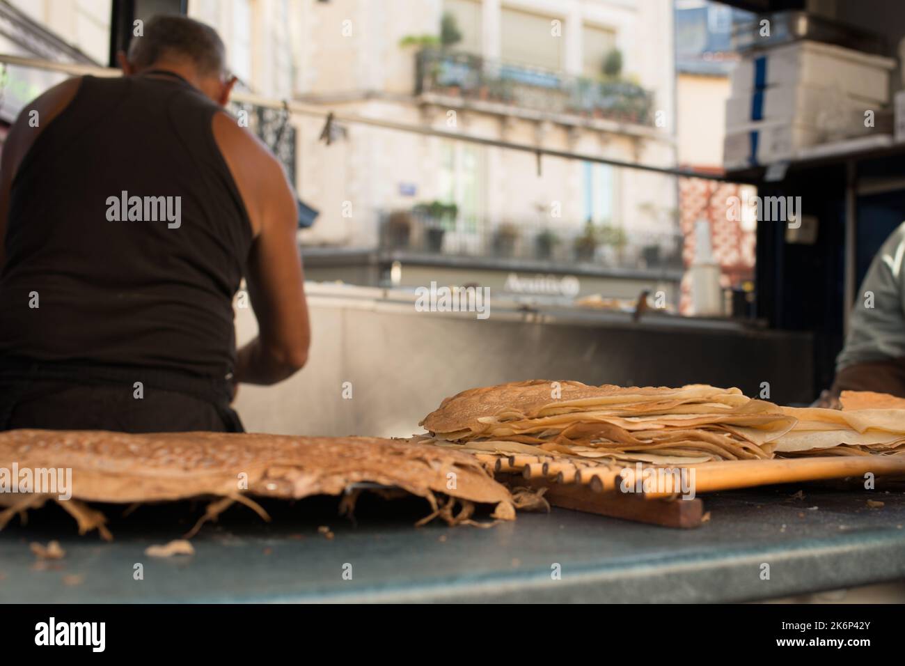 Persona irriconoscibile che cucina crepes in un camion alimentare. Francia Foto Stock