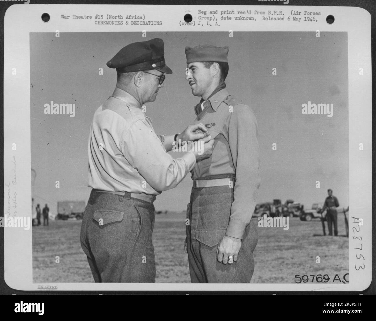 Il capitano George W. Long di Lexington, Mo., pilota attaccato ad un gruppo di combattenti americano che opera in Medio Oriente come parte dei Nono Stati Uniti Air Force, riceve la distinta Croce volante dal generale Lewis H. Brereton, comandante generale di Foto Stock