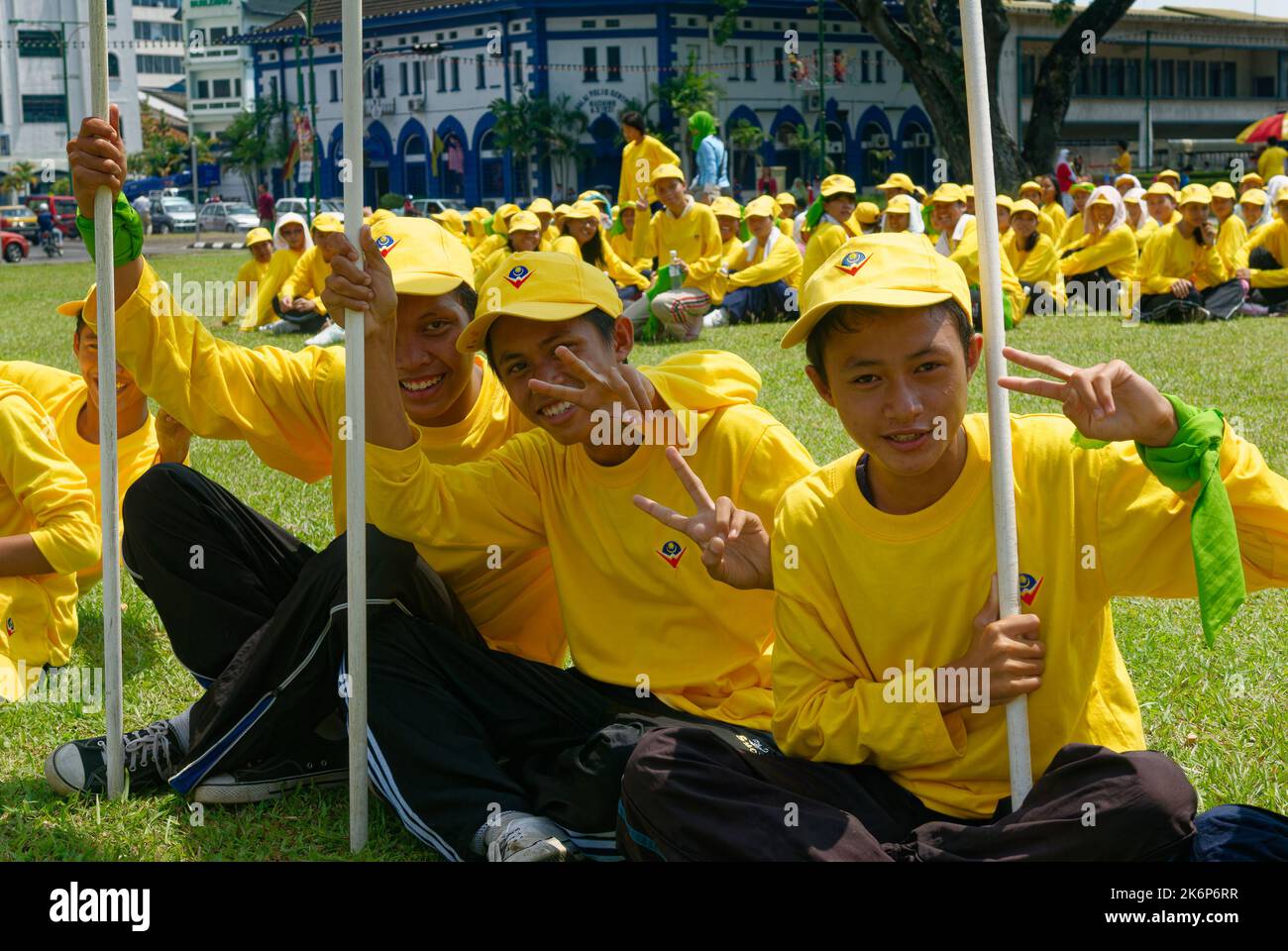 I bambini delle scuole con le bandiere malesi che si riuniscono per practive per il giorno di Merdeka, il giorno nazionale della Malesia Foto Stock