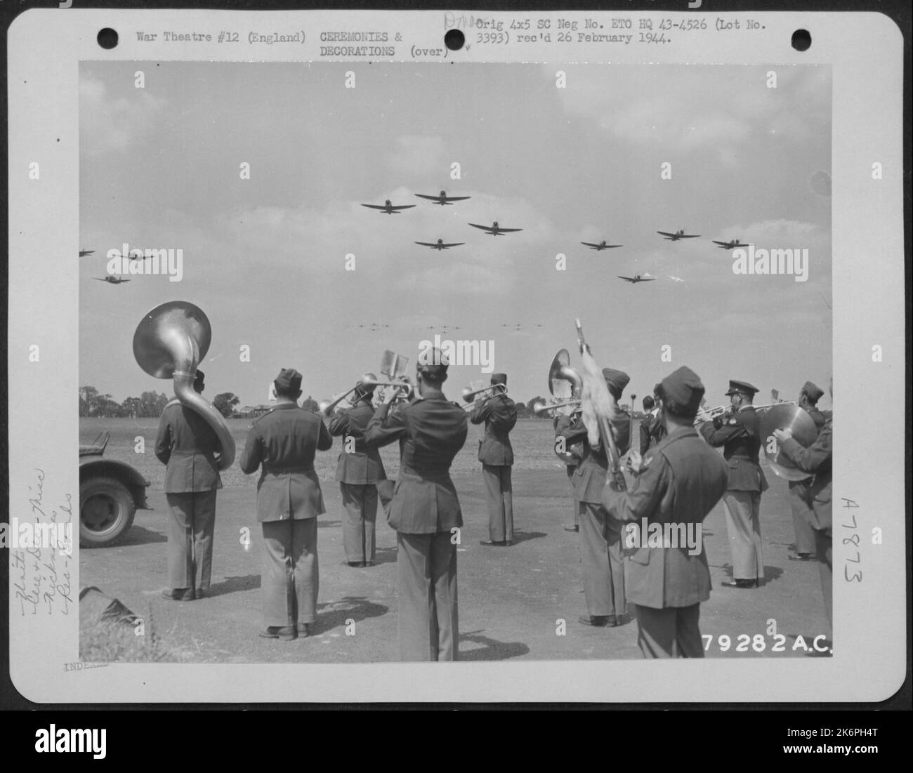 Mentre suona la band del gruppo di bombe del 493Rd 'The Flying Yanks', Republic P-47s Fly overhead come tributo a sua altezza reale, la duchessa del Kent, durante la sua visita ad una base aerea a Dibden, Inghilterra. 24 giugno 1943. Foto Stock