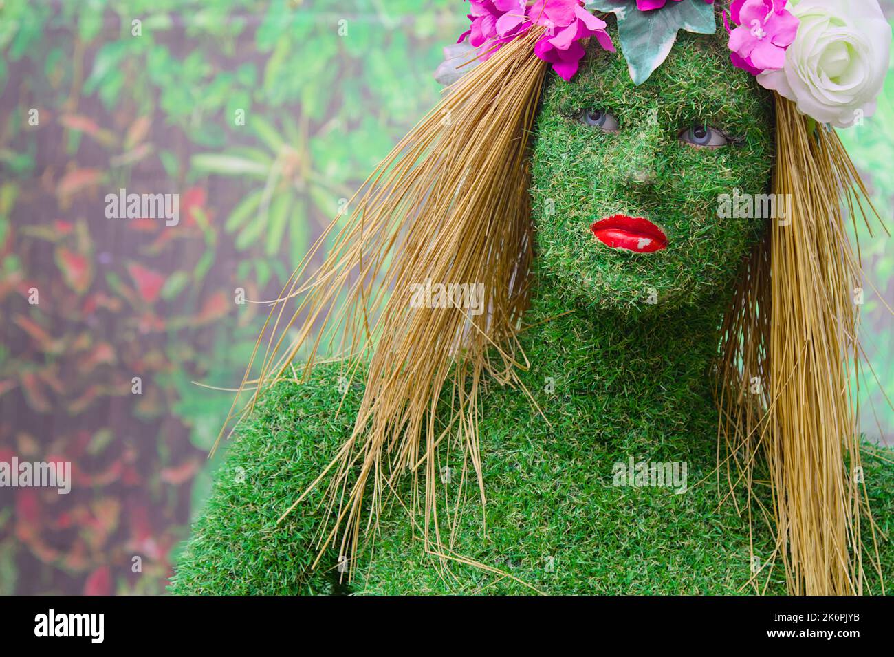 Manichino ricoperto di erba plastica Fake con capelli di paglia e fiori, Bournemouth UK Foto Stock