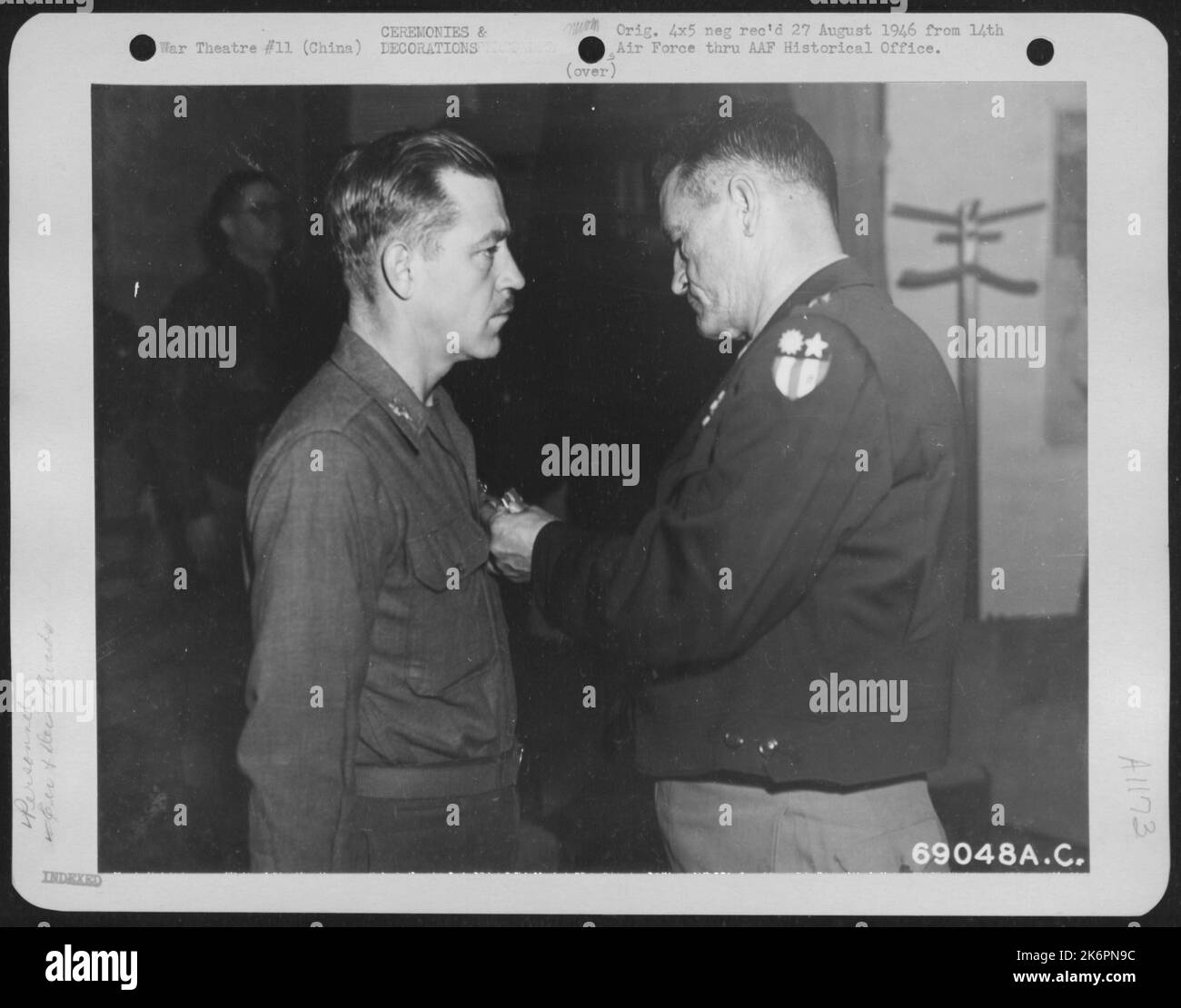 Quartier generale, quattordicesimo Air Force, Cina -- il colonnello Louis R. Hughes, Jr., di Miami, Florida, riceve la Legione del merito dal generale maggiore Claire L. Chennault, comandante generale dell'aeronautica militare del 14th, il 9 febbraio 1945. Foto Stock