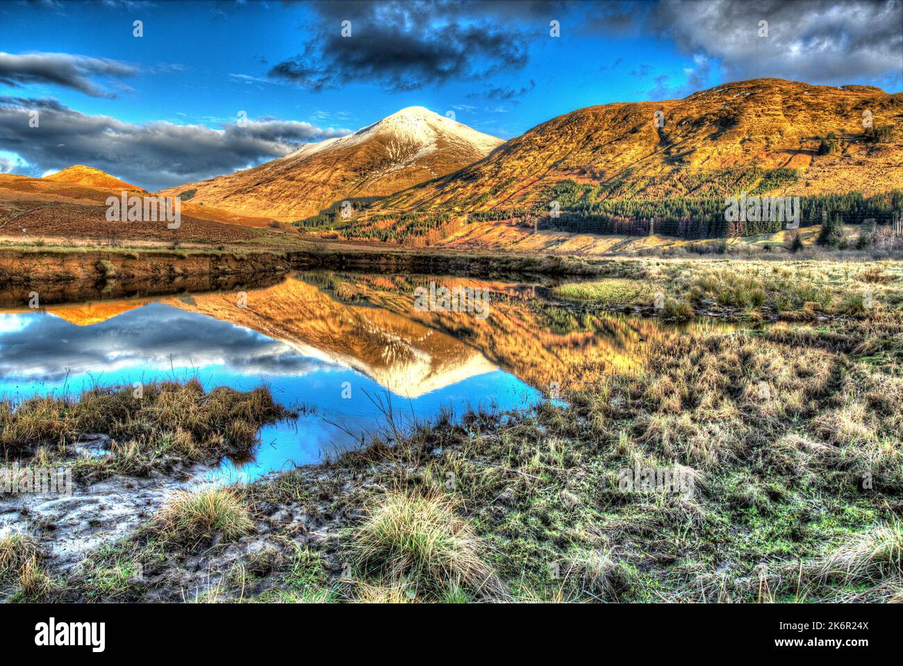 Zona di Crianlarich, Scozia. Vista artistica del tramonto sul fiume Fillan con un ben più innevato sullo sfondo. Foto Stock