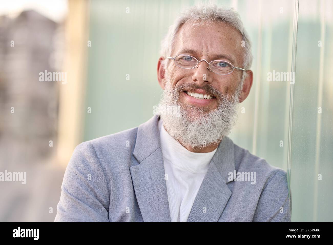Sorridente uomo d'affari anziano felice in piedi all'aperto, ritratto alla testa. Foto Stock