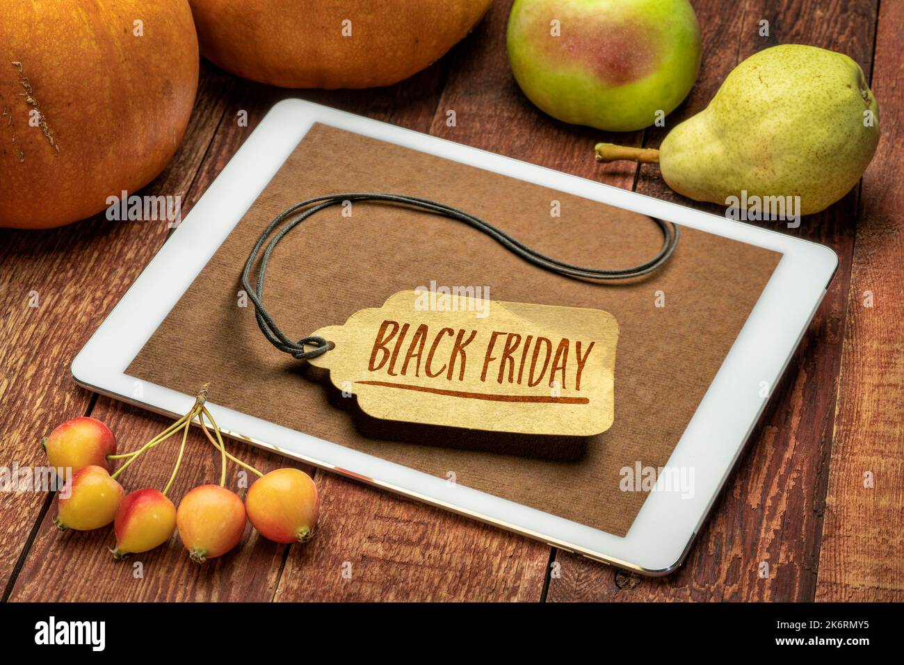 Black Friday segno di vendita - un cartellino del prezzo su una tavoletta digitale circondata da frutta e zucca Foto Stock