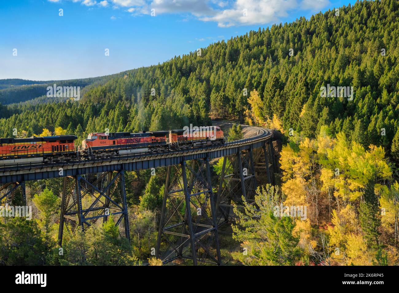 treno che passa sopra un alto traliccio sotto il passo di mullan in autunno vicino austin, montana Foto Stock