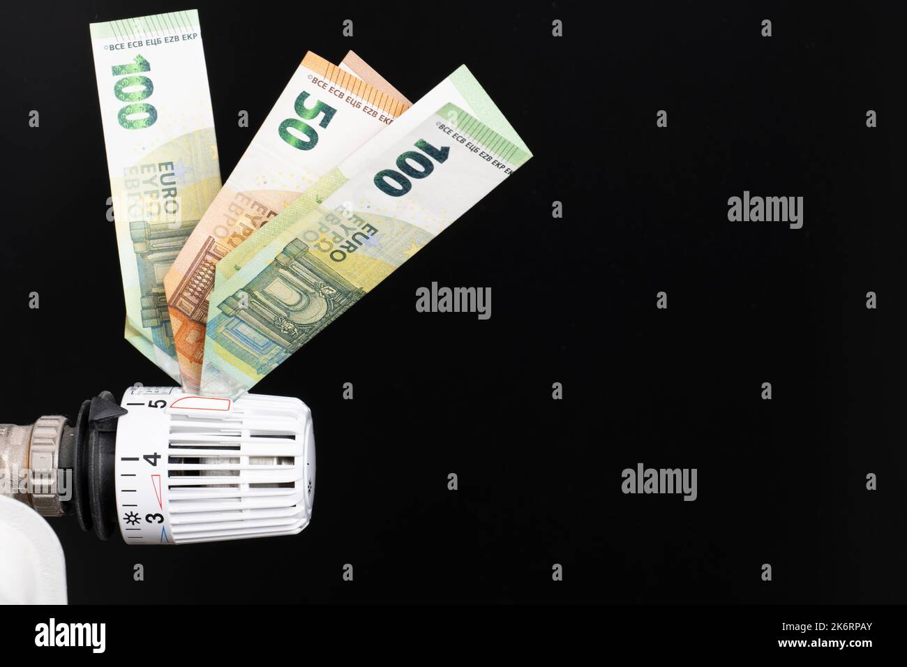 Termostato di riscaldamento, dotato di banconote in euro, fondo nero Foto Stock