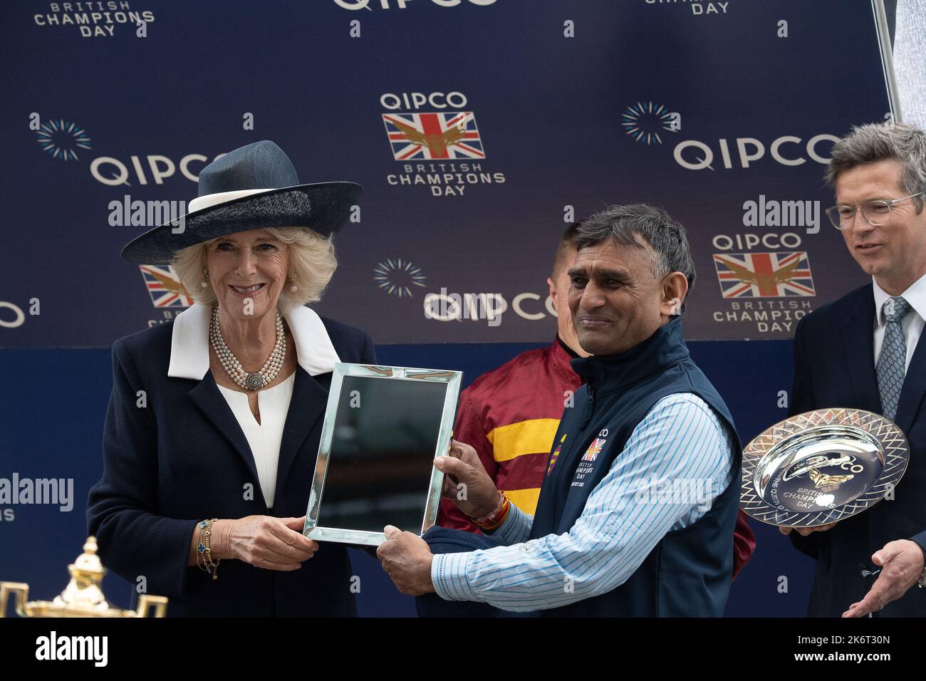 Ascot, Berkshire, Regno Unito. 15th ottobre 2022. Lo sposo vincente. Camilla, Regina Consort fa la presentazione ai vincitori delle Queen Elizabeth II Stakes. Horse Bayside Boy guidato dal jockey Tom Marquand ha vinto la gara. L'allenatore Roger Varian di Newmarket e la moglie Hanako Sonobe hanno ricevuto un premio insieme ai proprietari Teme Valley e Ballylinch Stud Credit: Maureen McLean/Alamy Live News Foto Stock