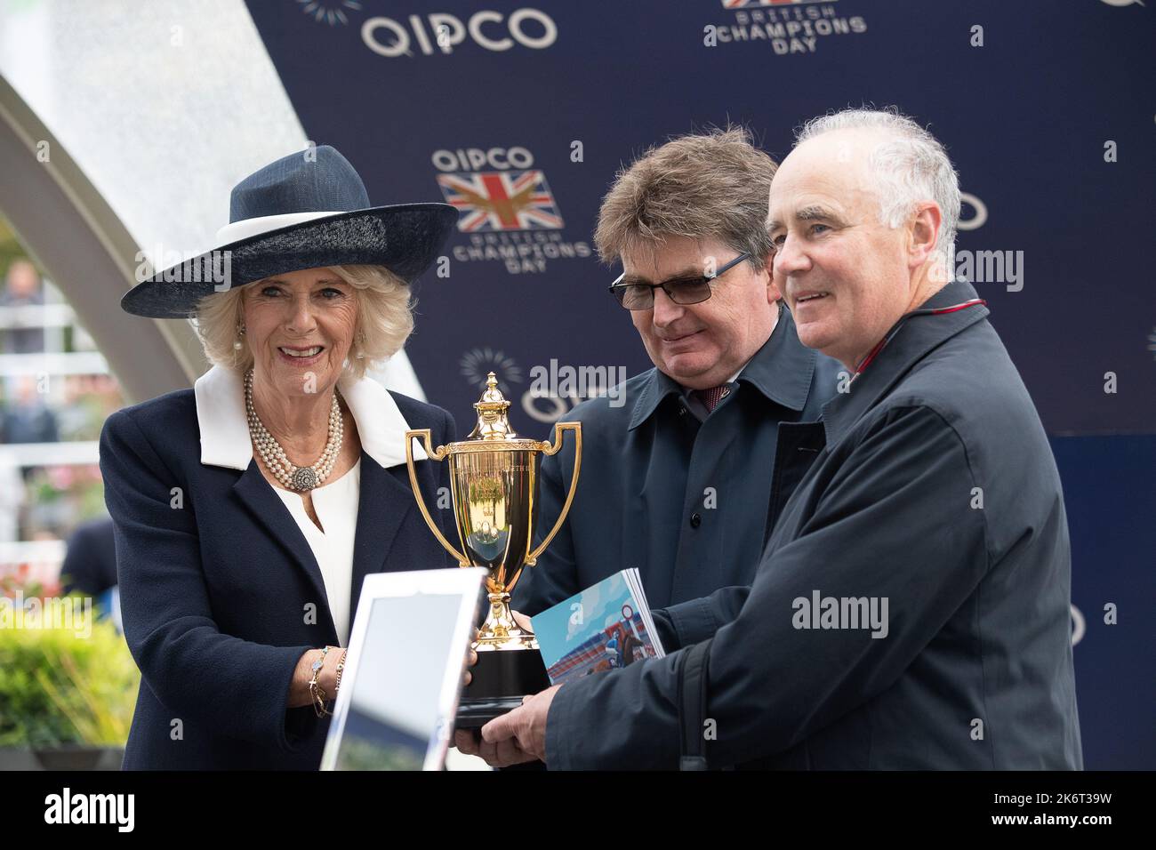 Ascot, Berkshire, Regno Unito. 15th ottobre 2022. Camilla, Regina Consort fa la presentazione ai vincitori delle Queen Elizabeth II Stakes. Horse Bayside Boy guidato dal jockey Tom Marquand ha vinto la gara. L'allenatore Roger Varian di Newmarket e la moglie Hanako Sonobe hanno ricevuto un premio insieme ai proprietari Teme Valley e Ballylinch Stud Credit: Maureen McLean/Alamy Live News Foto Stock