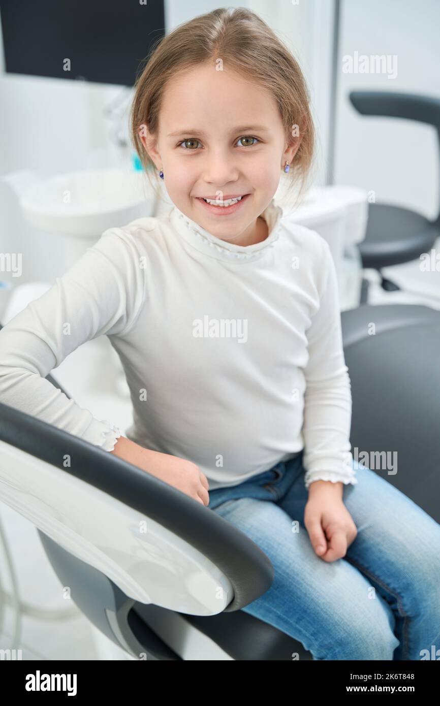 Giovane paziente seduto in studio dentistico dopo l'esame dei denti Foto Stock