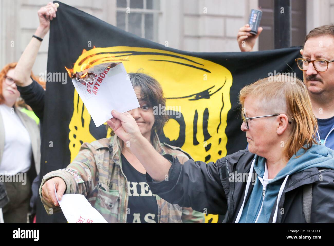 Londra, Regno Unito. 14th Ott 2022. Un protester della ribellione di estinzione brucia una bolletta energetica come i sostenitori dimostrano fuori Downing Street contro la crisi del cambiamento climatico e l'aumento delle bollette energetiche. Credit: SOPA Images Limited/Alamy Live News Foto Stock