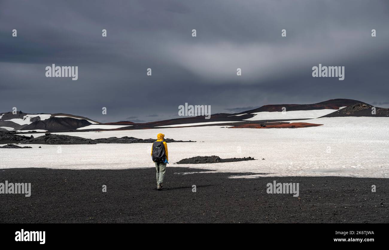Escursionisti in un paesaggio vulcanico innevato con sabbia vulcanica e lava pietrificata, cratere del vulcano Askja, altopiani islandesi, Islanda Foto Stock