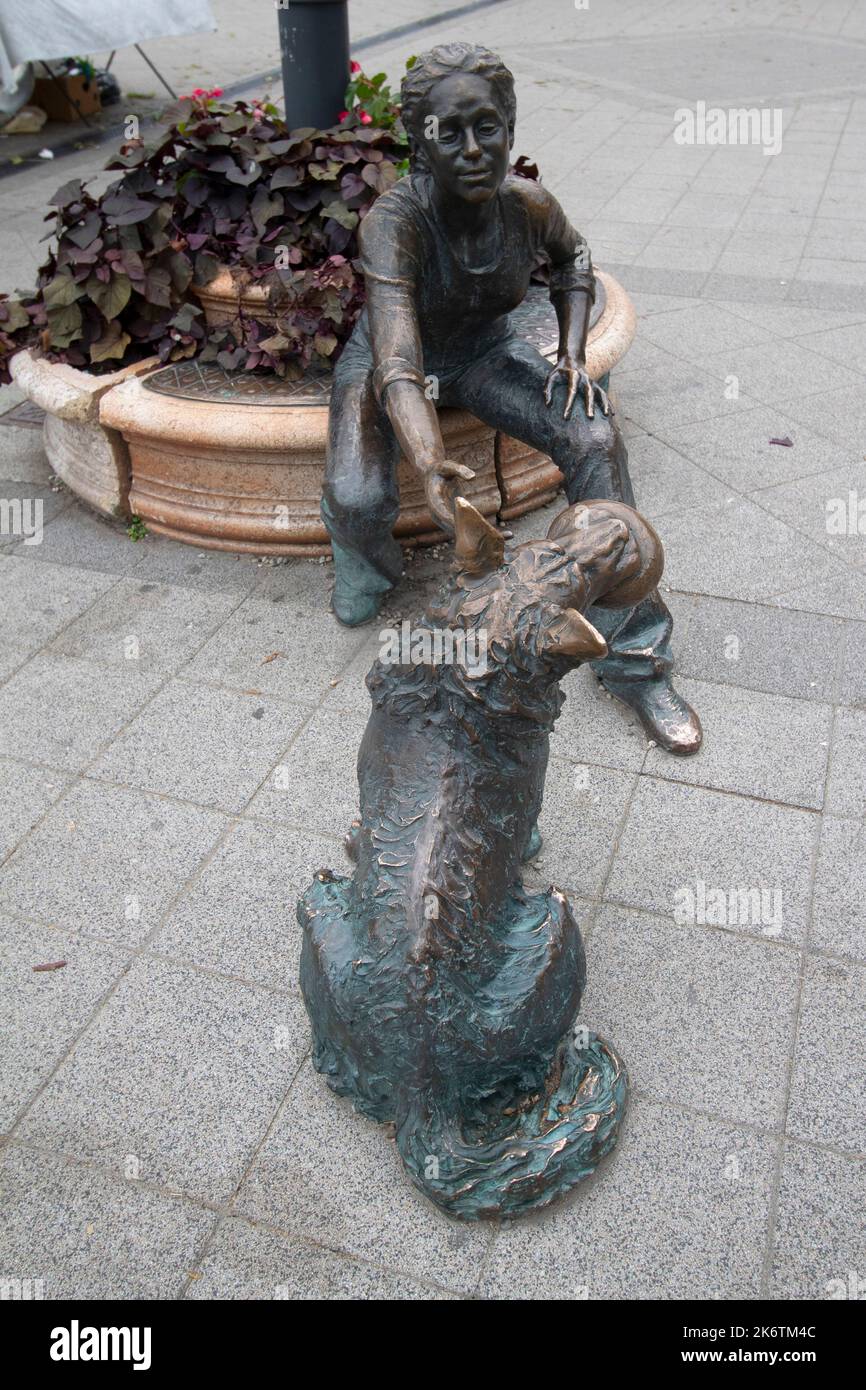 Scultura in bronzo a grandezza naturale di una ragazza che gioca a palla con il suo cane dello scultore Raffay Dávid, Budapest Ungheria Foto Stock
