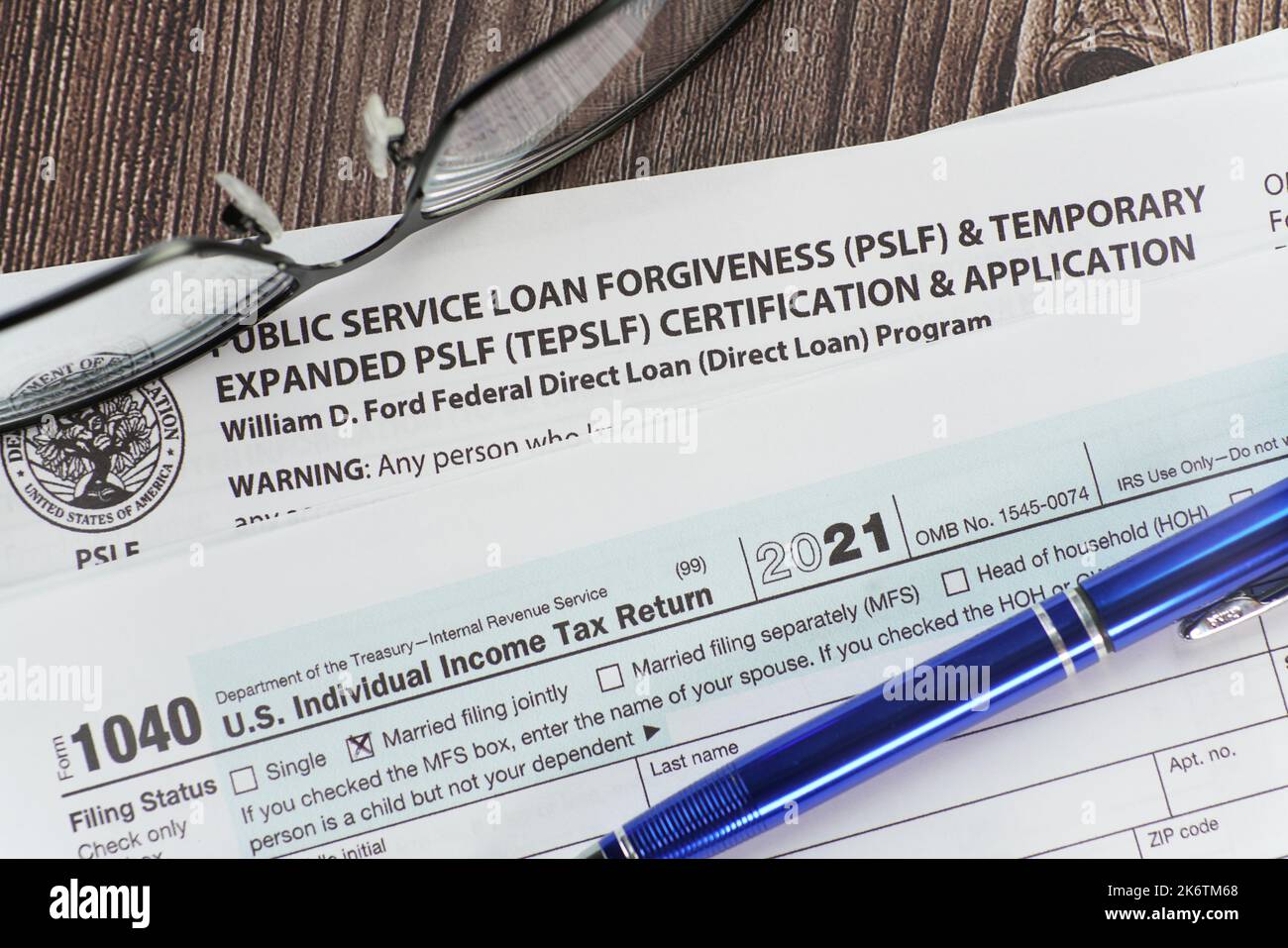 Primo piano di domanda di perdono prestito studente con informazioni fiscali e occhiali. Foto Stock