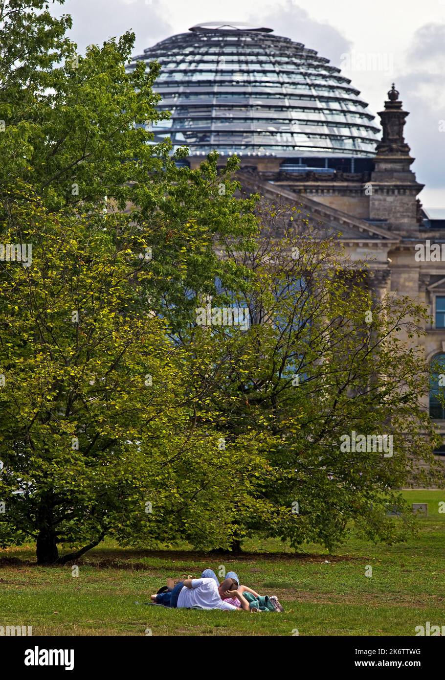 Due persone giacciono sulla Platz der Republik di fronte al Reichstag, Bundestag tedesco, distretto governativo, Berlino, Germania Foto Stock