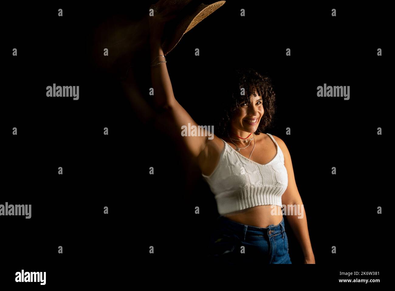 Vista temporizzata della donna che muove un cappello. Esposizione lunga, sfocatura del movimento. Donna felice. Salvador, Brasile. Foto Stock