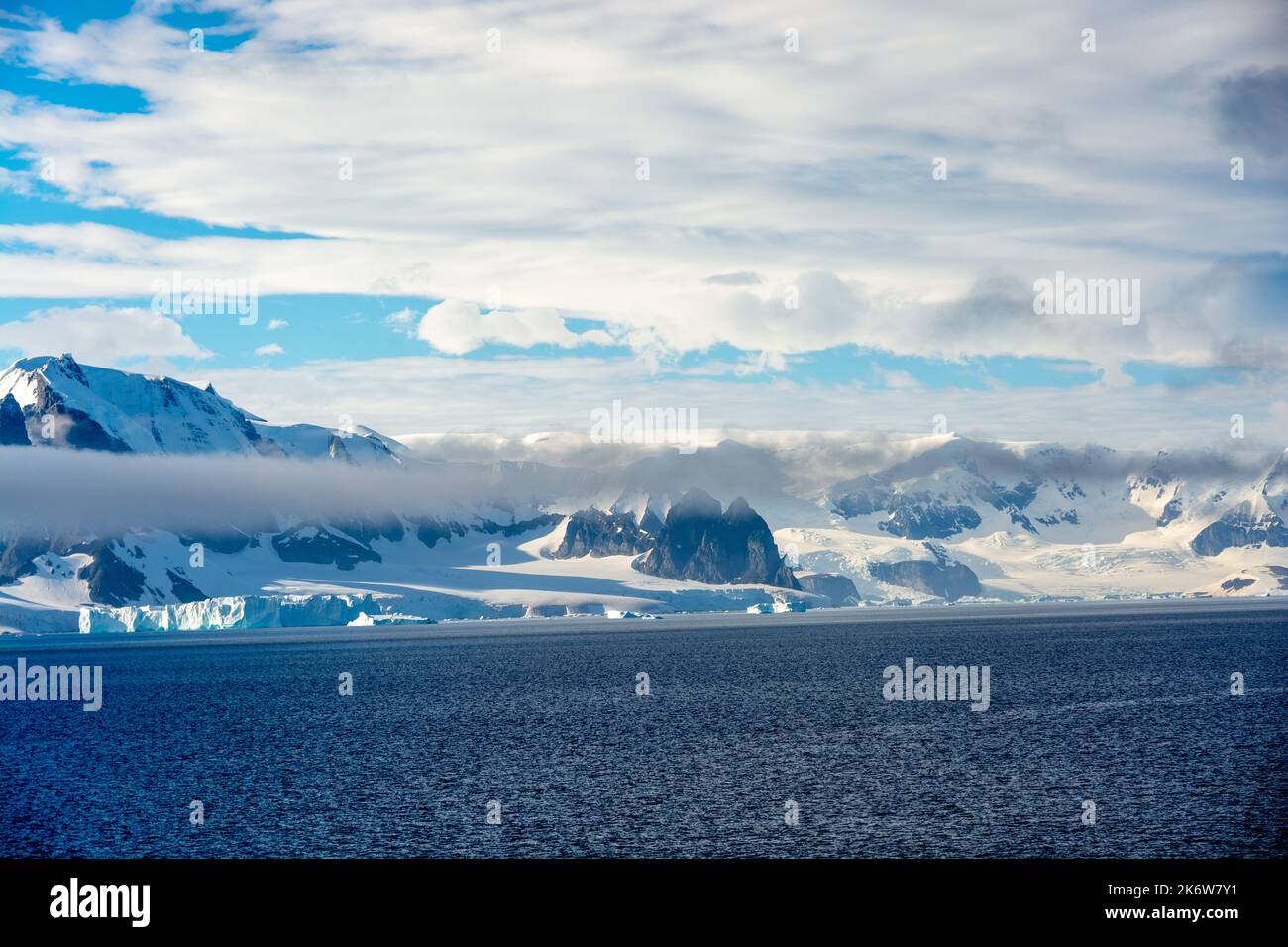 montagne e coste ricoperte di nube e neve. pinnacoli di sable (centro) guardando verso il canale di errara a destra. penisola antartica. antartide Foto Stock