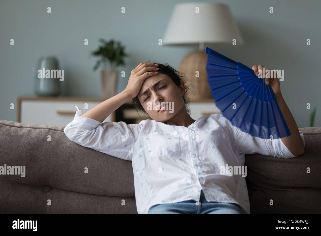 La donna indiana soffre di calore all'interno del freddo stesso ventilatore ondeggiante Foto Stock