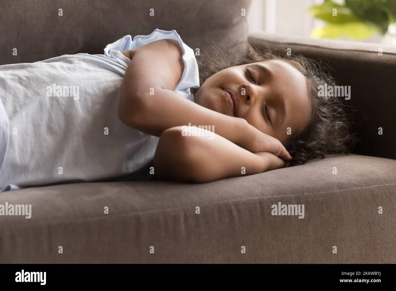 Bambina indiana che dorme sul divano di casa Foto Stock