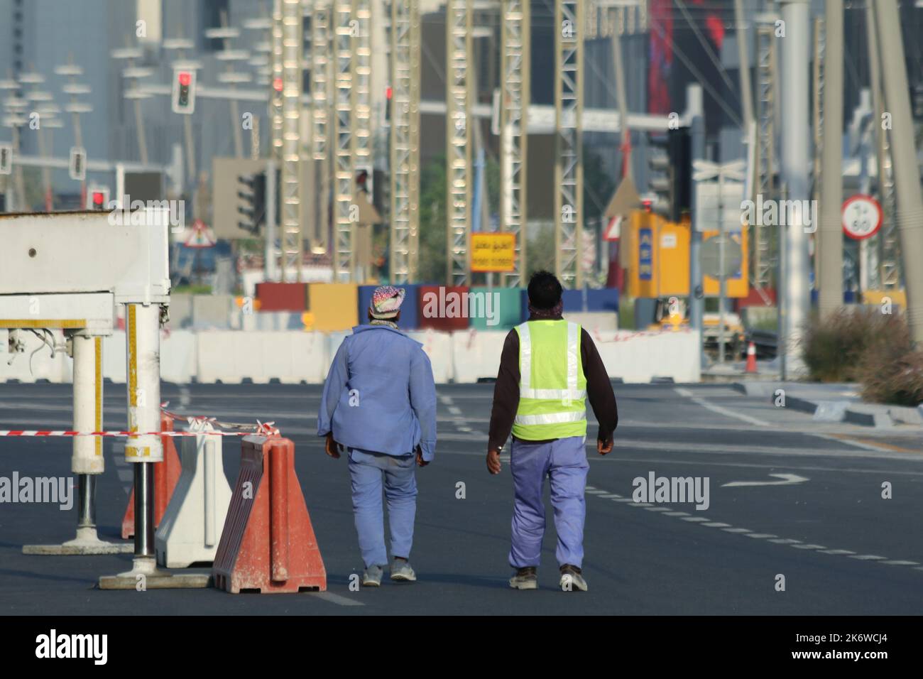 Vista di due lavoratori che camminano per le strade di FIFA 2022 Fan Village Foto Stock