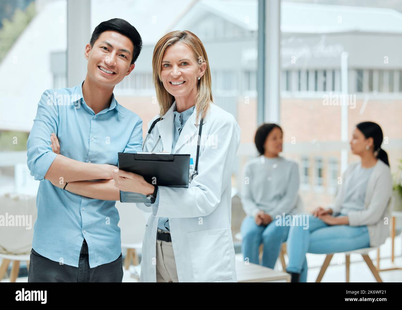 È un combattente. un medico maturo e il suo paziente discutono i suoi ultimi risultati in sala d'attesa. Foto Stock