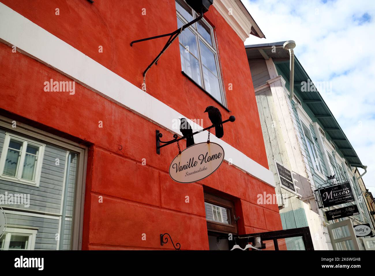 Due corvi neri seduti su un cartello del negozio in un vecchio edificio patrimonio storico di Porvoo, Finlandia Foto Stock