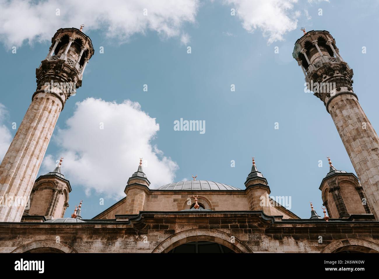 Una facciata vista di una grande moschea con minareto contro il cielo blu con nuvole di sfondo. Concetto Ramadan. Foto di alta qualità Foto Stock
