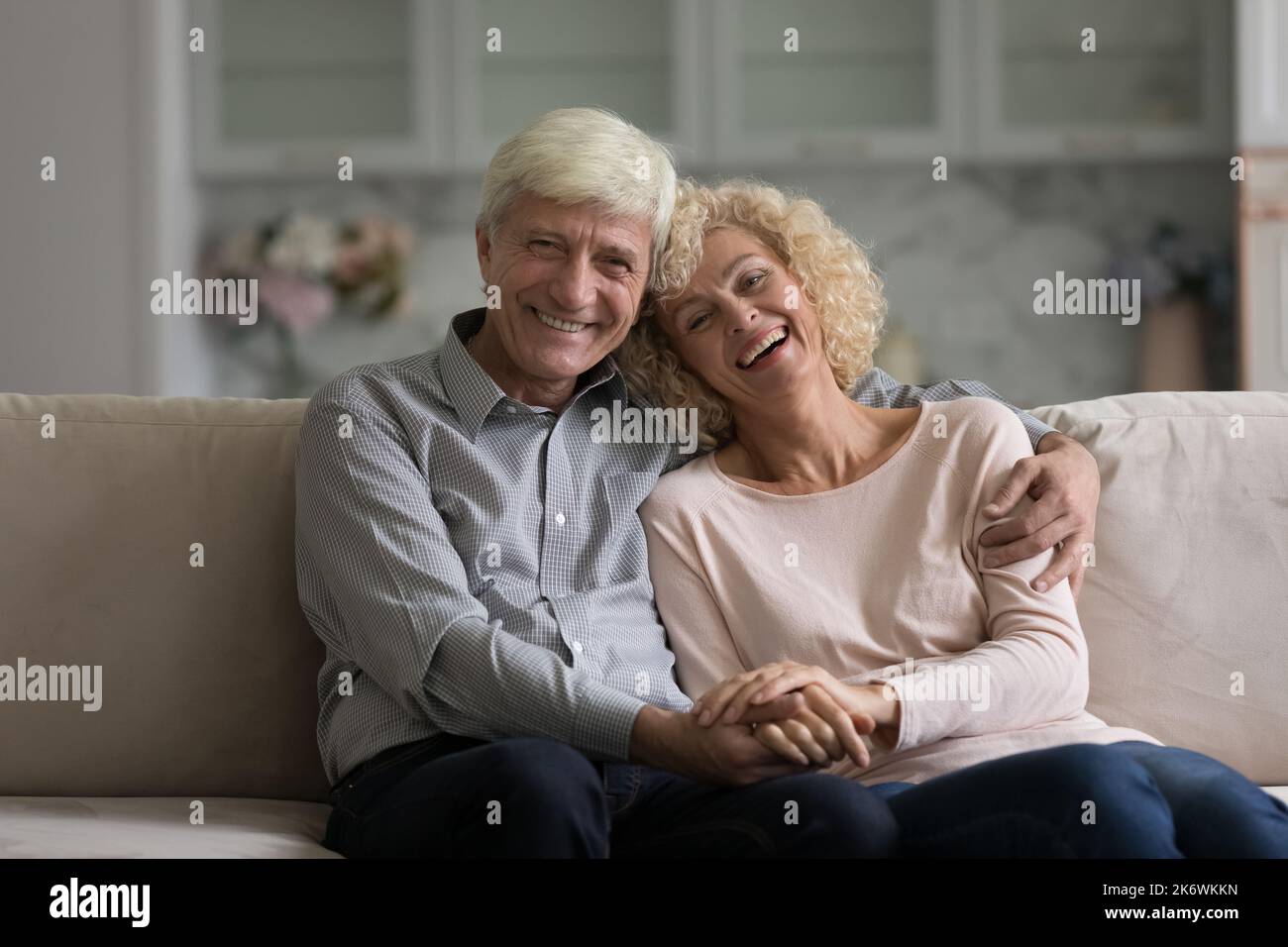 Ritratto di coppia pensionato posa per fotocamera a casa moderna Foto Stock