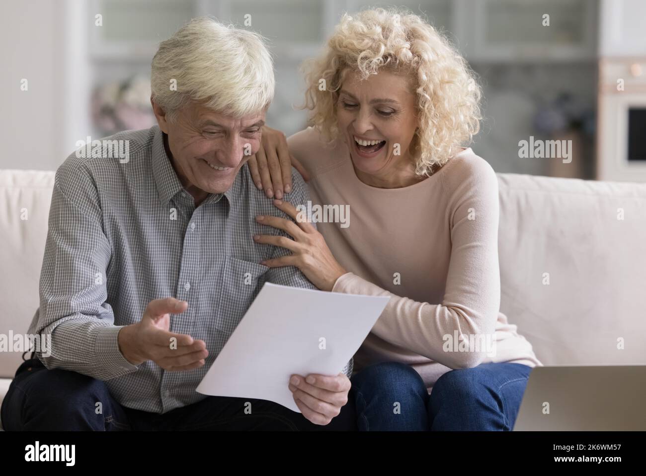I coniugi ottengono le notizie grandi, leggono la notifica ricevuta della banca ritengono overjoyed Foto Stock