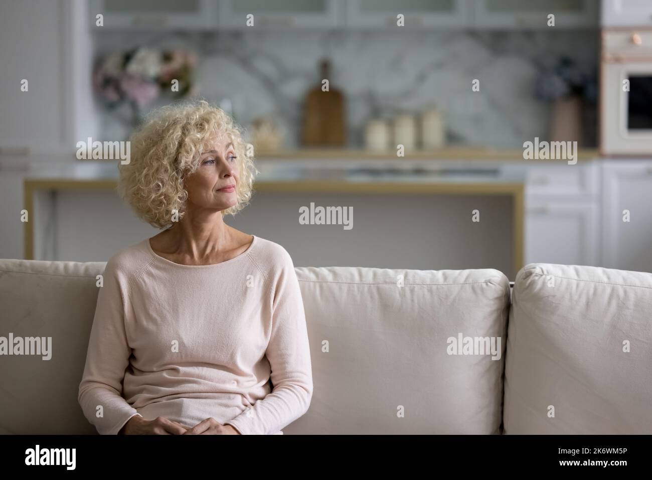 Premuroso attraente bionda di mezza età che fissare in lontananza Foto Stock