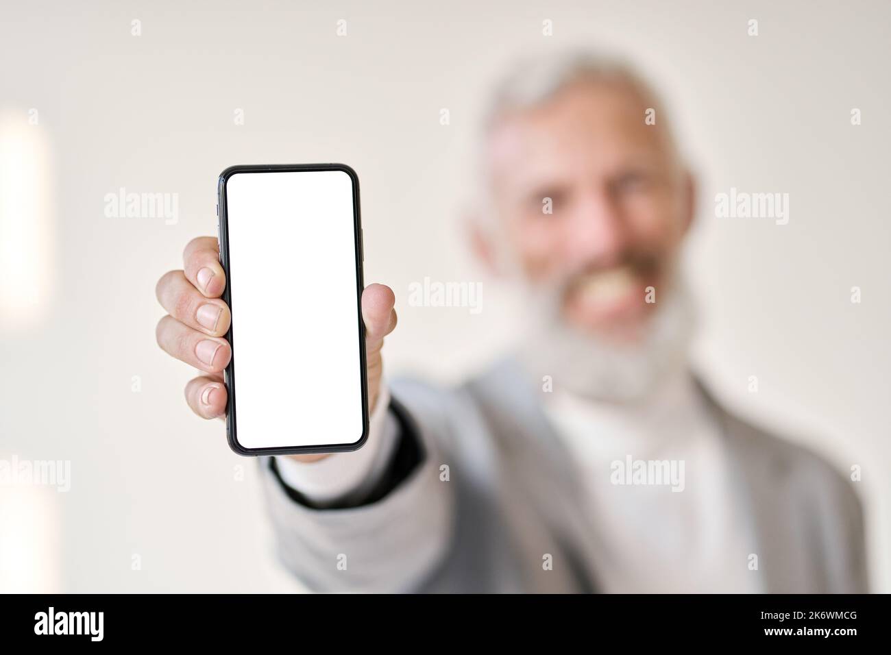 Uomo d'affari che indossa una tuta per smartphone con schermo bianco isolato. Foto Stock