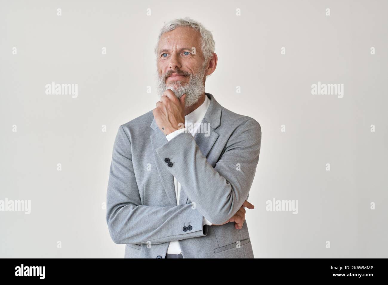 Uomo d'affari anziano premuroso che guarda lontano pensando isolato sul bianco. Foto Stock