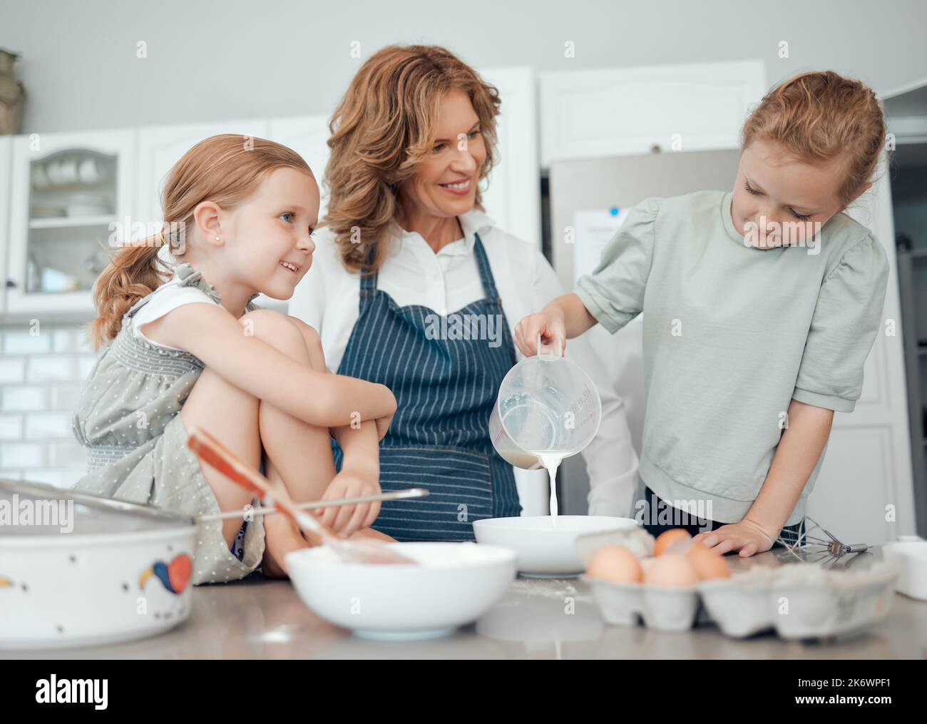 Youre fare un lavoro così meraviglioso. una nonna che cuoce con le sue due nipoti a casa. Foto Stock