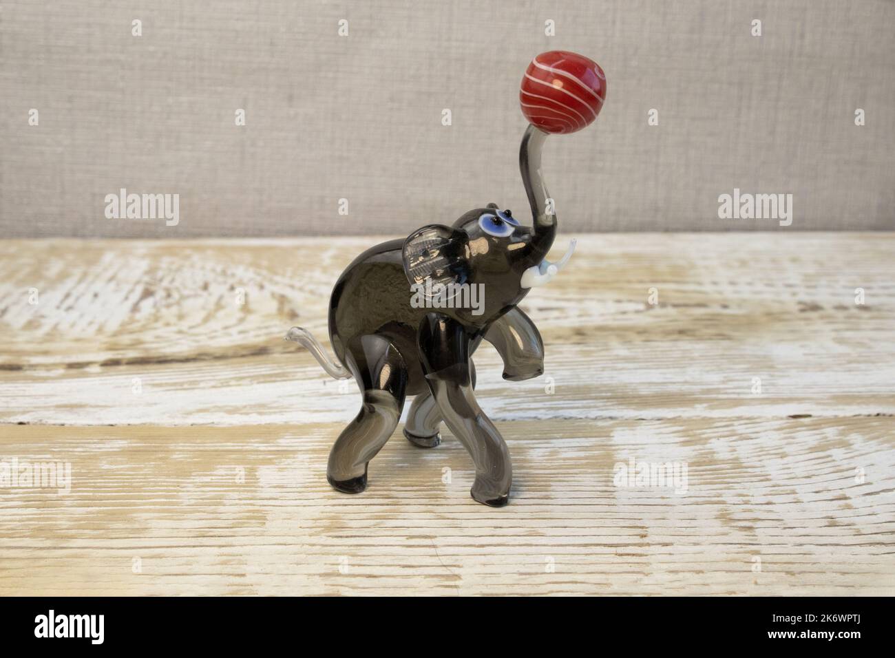 Figurina di elefante in vetro nero su sfondo di legno ruvido vista frontale Foto Stock
