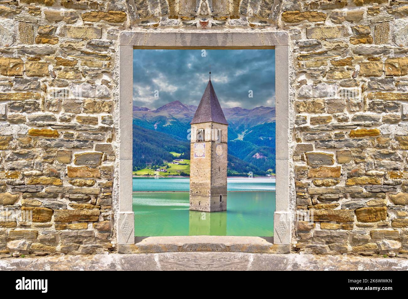 Campanile sommerso di Curon Venosta o Graun im Vinschgau sul lago di Reschen vista panoramica attraverso il cancello muro di pietra, Alto Adige regione Italia Foto Stock