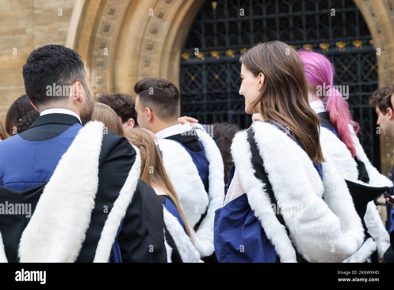 29 6 2022 vista posteriore di studenti laureati di sesso maschile e femminile con abito e indirizzo accademico a piedi nel campus della Cambridge University, Regno Unito durante congre Foto Stock