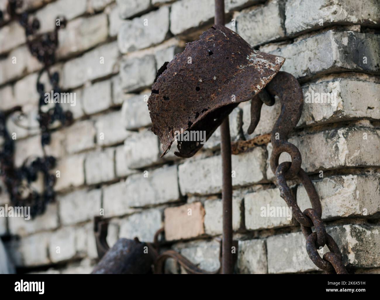 casco in acciaio arrugginito su parete in mattoni. vecchio casco dei tempi della guerra Foto Stock