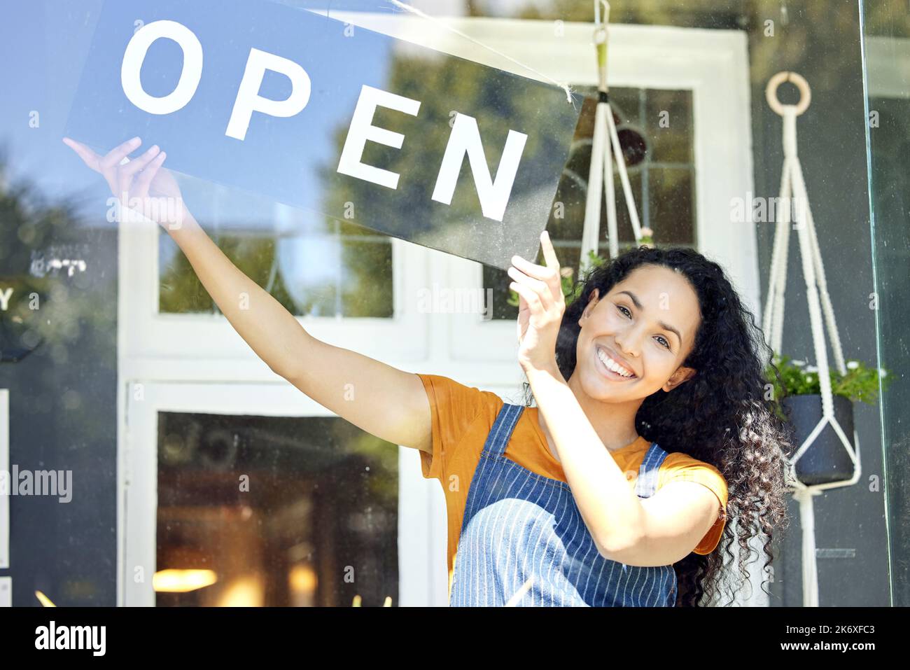 Il suo ufficiale. una giovane fiorista femminile che tiene un cartello aperto sul lavoro. Foto Stock