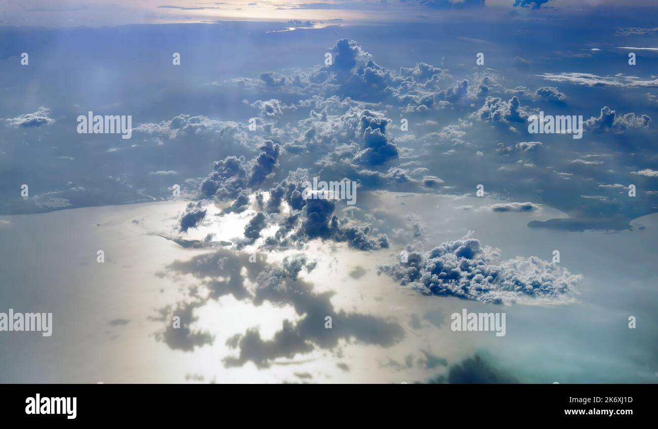 L'acqua di mare ha riflesso le calde luci del tramonto, il paesaggio nuvoloso nel cielo che getta la loro ombra sull'oceano, la tranquilla scena del cielo serale Foto Stock